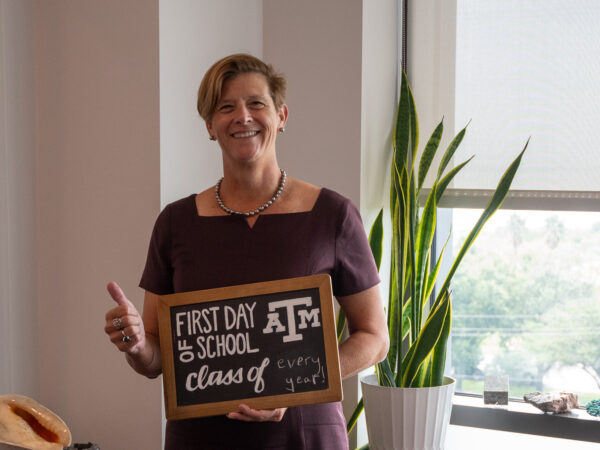 Debbie Thomas holding a sign that says "first day of school"