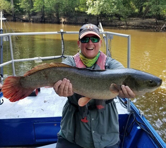 Katie St. Clair ’07 holding a large fish.