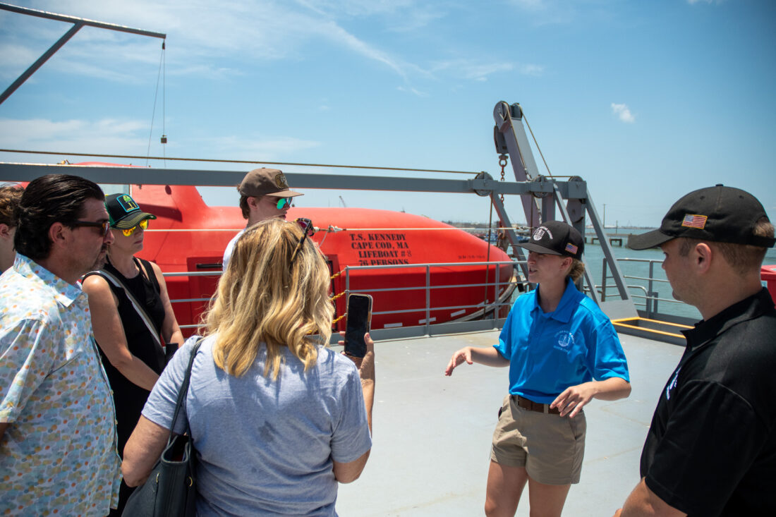 Tyler Heffernan describing lifeboats during a TS Kennedy tour to Summer Sea Term 2023 Galveston Dock Party attendees