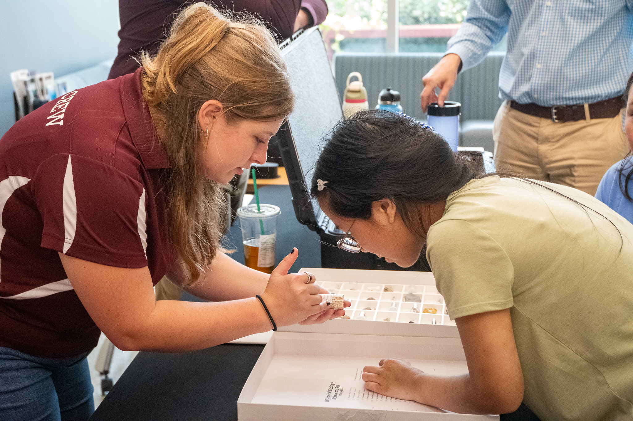 Student showing visitor to Aggieland Saturday by the Sea a sample from a historical geology reference set