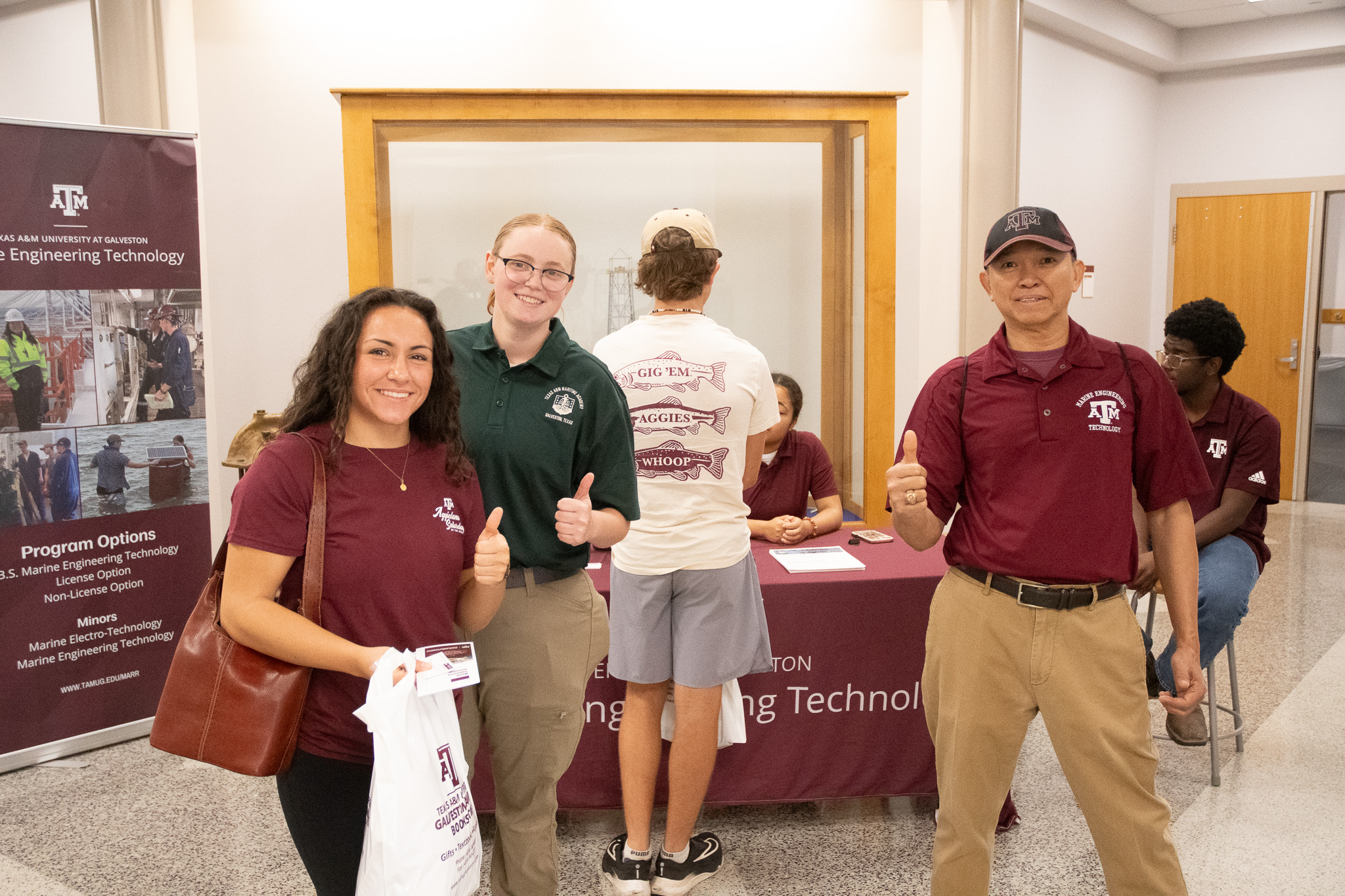 A visitor at Aggieland Saturday by the Sea with cadet Melanthea Ussery and laboratory manager Kevin Winn