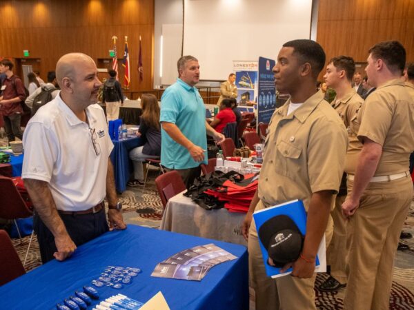 A student talking with employers at a career fair.