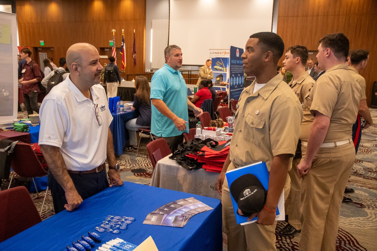 A student talking with employers at a career fair.