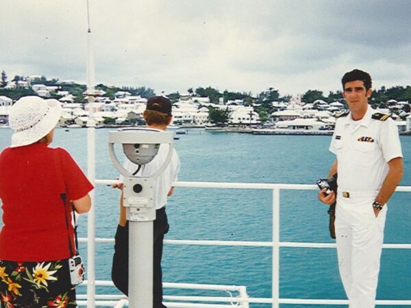 Jason Tieman, right, standing in front of a railing overlooking the water