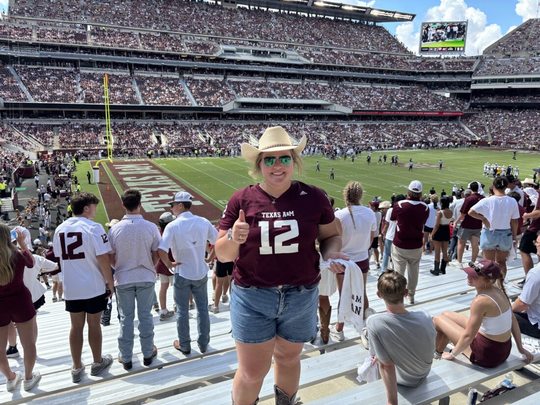 DeYoung in a cowboy hat and TAMU Football jersey standing in Kyle Field