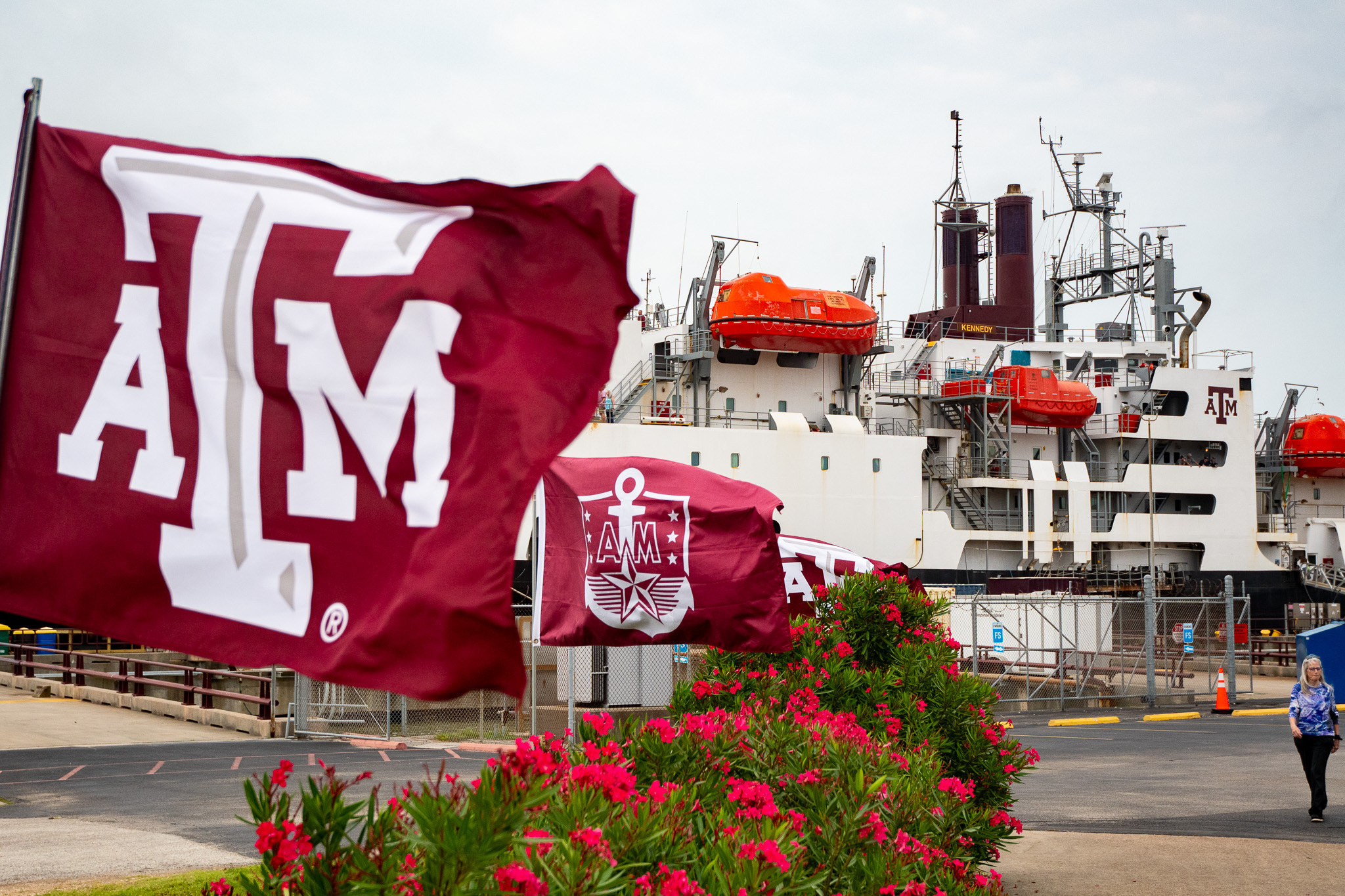 Docked TS Kennedy behind Texas A&M flags and campus landscaping