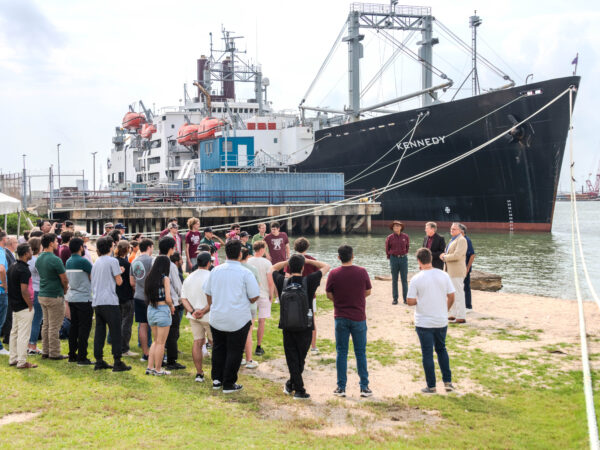A crowd gathered by the dock at Shell Beach at Texas A&M University at Galveston